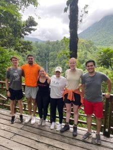 Six students posing in front of Arenal Volcano